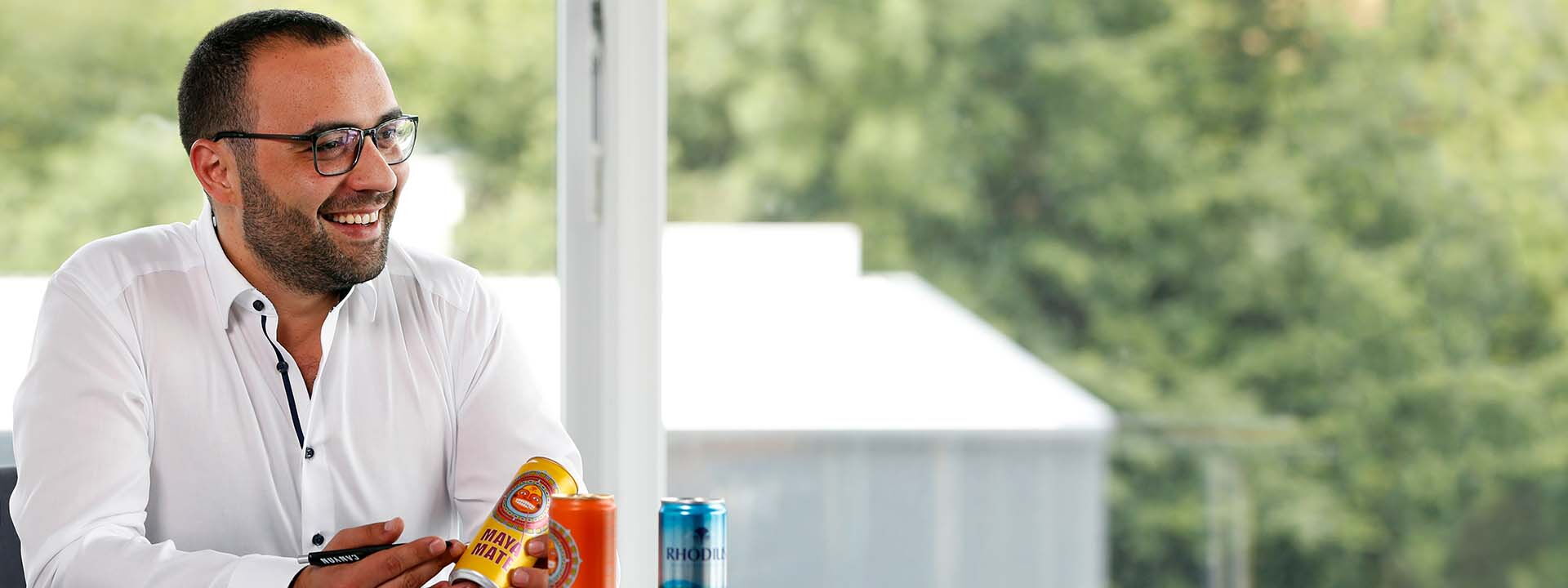 Man in white shirt and glasses smiles and looks to the side.